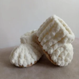 Handmade crochet baby booties in soft cream color with ribbed texture, cozy plush yarn, lightweight and comfortable newborn footwear by Calissi.