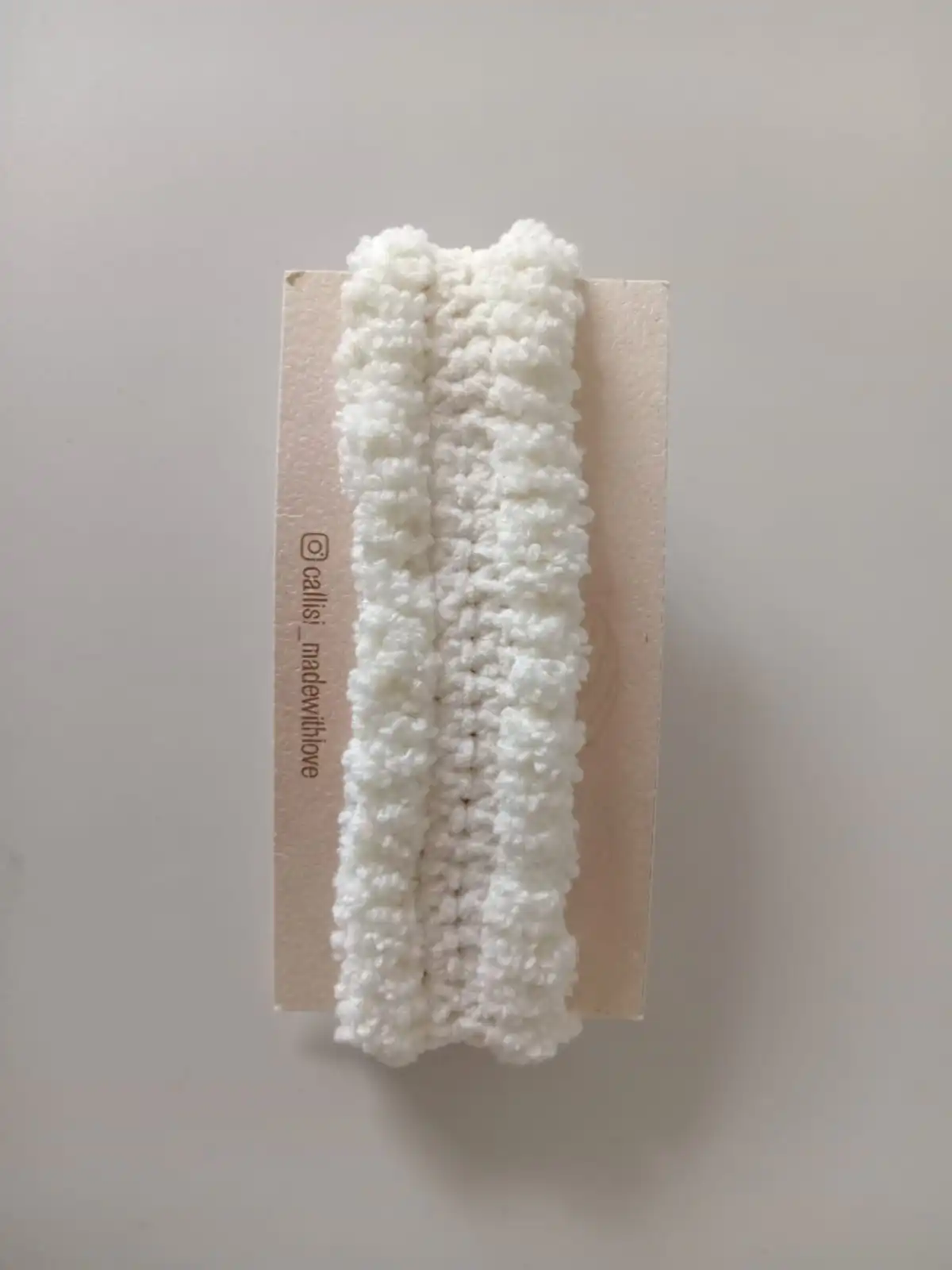 Handcrafted off-white crochet baby headband made with soft yarn, gentle and comfortable handmade accessory by Calissi