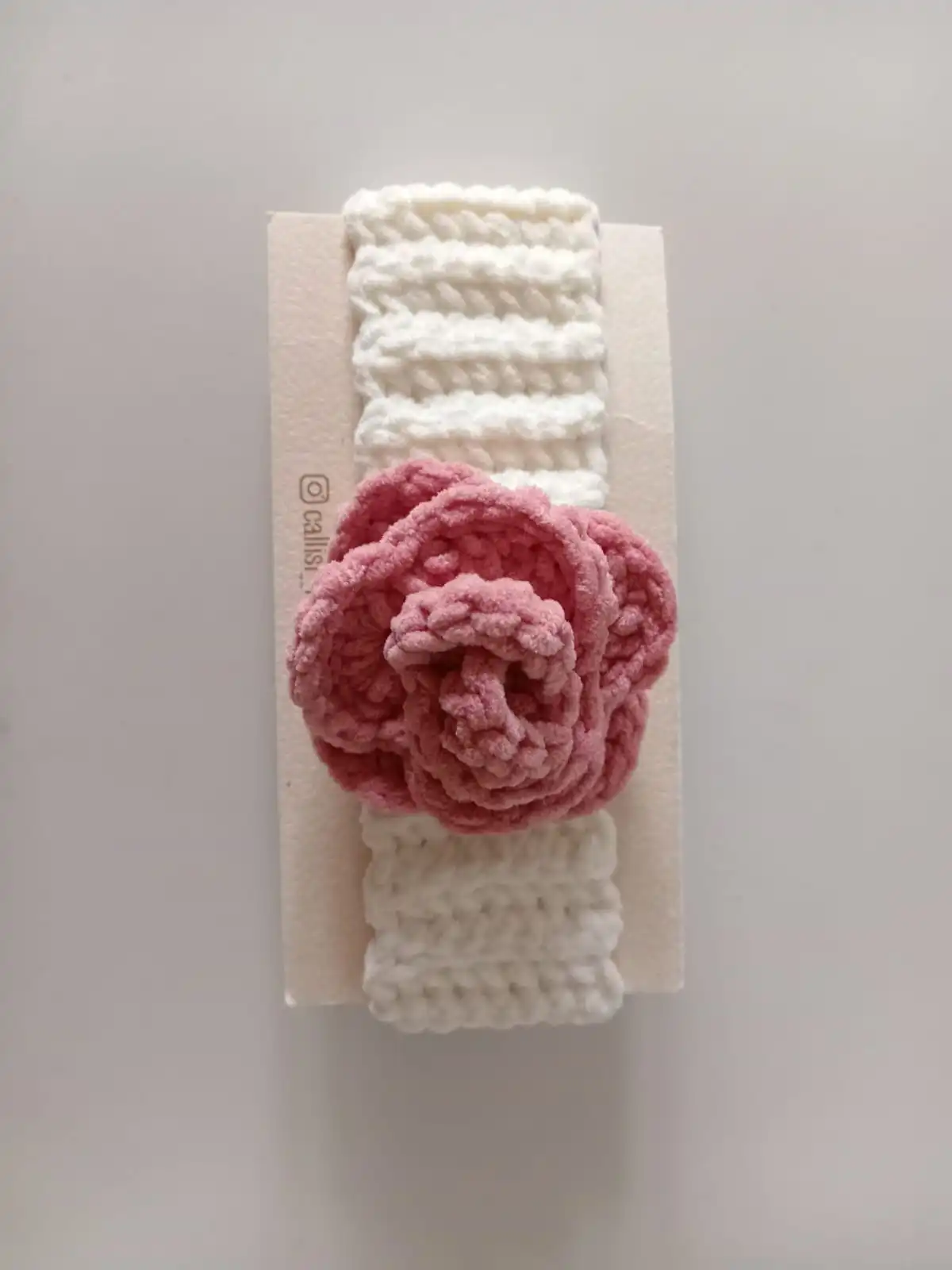 Handmade crochet baby headband with soft white band and blush pink crochet flower, premium handcrafted hair accessory by Calissi